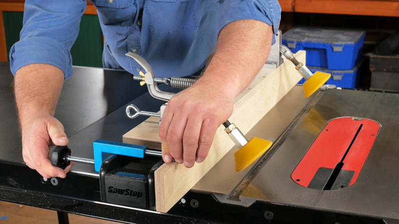 A set of universal fence clamps holds the L-shaped auxiliary fence in place. The clamps shown here are fully adjustable for most fence widths.